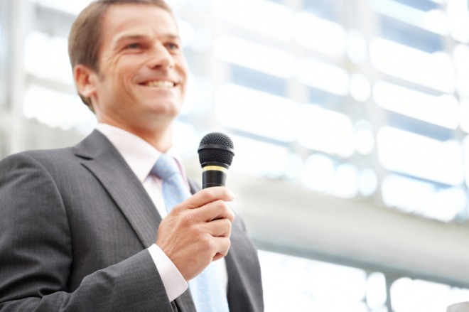 Businessman Speaking With a Microphone