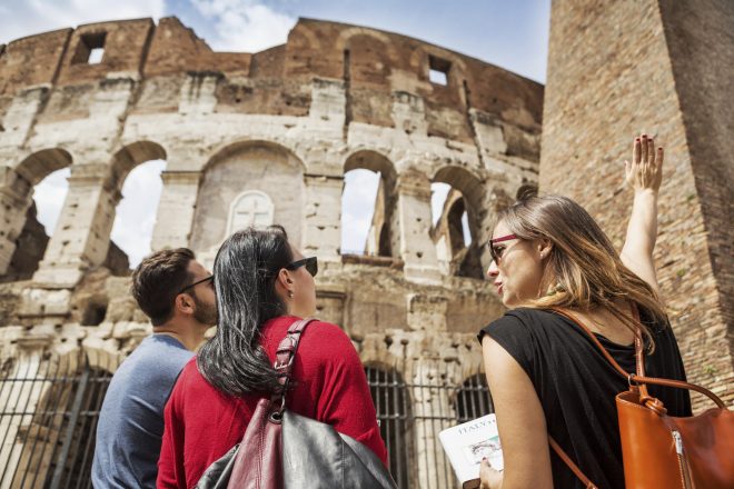 Guide explaining to tourists the Coliseum of Rome